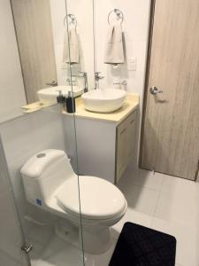 Baño blanco con aseo y lavamanos en Habitación premium sede 3, en Ibagué