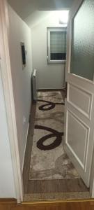 a hallway with a door and a carpet on the floor at Sve u jednom in Bijelo Polje
