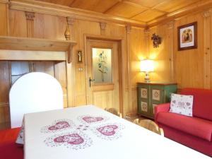 una sala da pranzo con tavolo e divano rosso di OLIMPIA LODGE a Cortina dʼAmpezzo