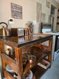 uma cozinha com uma mesa de madeira com panelas e frigideiras em TheeHost@1924 em Mmabatho
