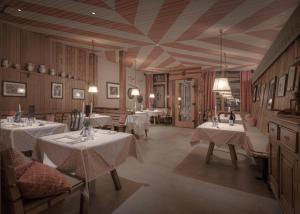 un ristorante con tavoli con tovaglie bianche di Il Tyrol a San Candido
