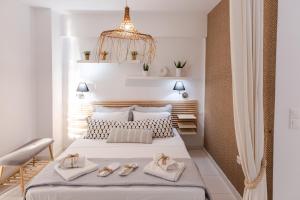 Un dormitorio con una gran cama blanca con zapatos. en Mary's Home, en Néa Artáki