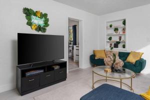 a living room with a large flat screen tv at Smart Bungalow: 10-min to UF, Central Location in Gainesville
