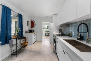 una cocina con encimeras blancas y cortinas azules. en Smart Bungalow: 10-min to UF, Central Location, en Gainesville