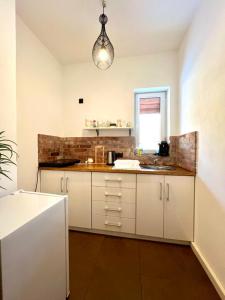 a kitchen with white cabinets and a sink and a window at Apartament Zimowa Cisza in Piwniczna-Zdrój