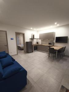 een keuken en een woonkamer met een blauwe bank en een tafel bij Villa Laura Holiday House 2 in Bologna