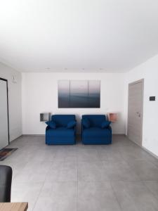 uma sala de estar com dois sofás azuis em Villa Laura Holiday House 2 em Bolonha