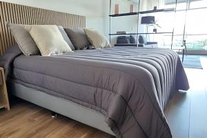 una camera da letto con un grande letto con una coperta a righe di Luxury and Modern Aptartment en Distrito Quartier a Buenos Aires