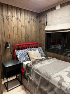 a bedroom with a red bed and a window at Trysil Moderna Lodge in Trysil