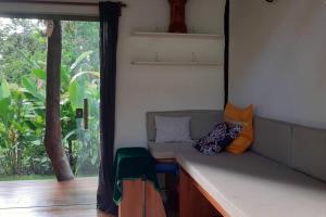 una habitación con un banco con almohadas y una ventana en Boutique Beach Chalet, Luzimares, Serra Grande-BA en Serra Grande