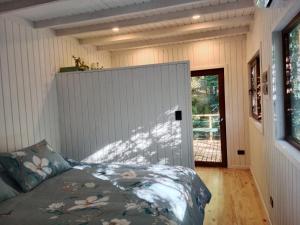 1 dormitorio con 1 cama en una habitación con puerta en CasaVerde Hostal Ecologico, en Malalcahuello