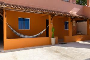 a house with a hammock on the side of it at Casa Sol de Búzios in Búzios