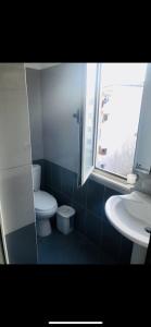 baño con aseo y lavabo y ventana en Berat2024, en Berat