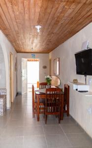 a dining room with a table and chairs and a television at Casa Sol de Búzios in Búzios