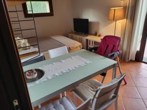 een kamer met een tafel en stoelen en een slaapkamer bij Romantica casa vacanza direttamente in piscina in Castiglione del Lago