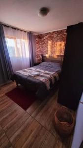 a bedroom with a bed and a brick wall at Casa en el centro de Pirque in Pirque