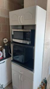 a microwave sitting on top of a cabinet in a kitchen at Casa en el centro de Pirque in Pirque