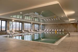 a large swimming pool with chairs and a swimming pool at Raspberry apartment and SPA in Dziwnów