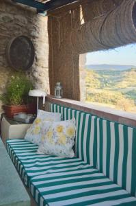 un banco con almohadas en el balcón con vistas en Borda de Fadrín, en Ipiés