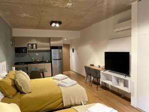 ein Schlafzimmer mit einem großen gelben Bett und einer Küche in der Unterkunft Fitz Cosmopolitan - Studio in Palermo Hollywood in Buenos Aires