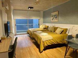 ein Schlafzimmer mit einem großen Bett und einer gelben Decke in der Unterkunft Fitz Cosmopolitan - Studio in Palermo Hollywood in Buenos Aires