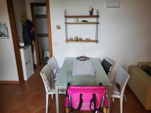 una mesa verde con sillas y una bolsa rosa. en Romantica casa vacanza direttamente in piscina, en Castiglione del Lago