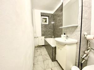 a white bathroom with a sink and a toilet at Twins Apartments 2 in Ploieşti