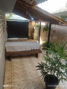 a patio with a bench under a pergola at Casa praia para temporada Parque Mambucaba Angra in Angra dos Reis