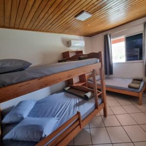 パリョサにあるPousada paraíso Ap próximo ao centro da praia de baixoの二段ベッド2台と窓のある寝室