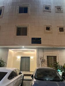 due auto parcheggiate di fronte a un edificio di شقه فندقيه فاخرة a Riyad