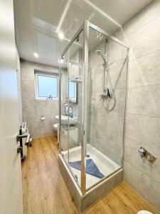 a bathroom with a shower with a glass door at Traumhafte Ferienwohnung zentral in Nordenham
