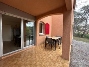 a patio with a table and chairs on a house at Domaine Valescure Appartement 1 ou 2 pieces vue jardin ou piscine in Saint-Raphaël