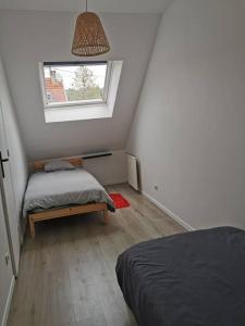 - une chambre mansardée avec 2 lits et une fenêtre dans l'établissement Maison Moisson 4-6 personnes 2 chambres, à Moisson