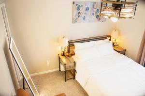 a bedroom with a bed and a nightstand with two lamps at HomeTel Premium Guest Suite w/ Private Entrance in Ypsilanti