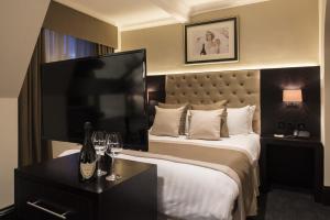 a hotel room with a bed and a television at The Vermont ApartHotel in Newcastle upon Tyne