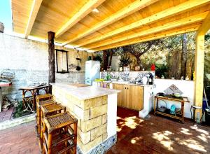 an outdoor kitchen with a counter and a refrigerator at Villa dell’Orsa in Cinisi