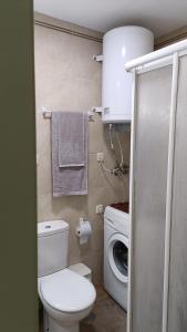 een badkamer met een toilet en een wasmachine bij Sun Love calypso in Mijas