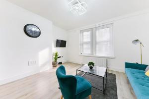 ein Wohnzimmer mit einem blauen Sofa und einem Tisch in der Unterkunft Modern London Apartment with WIFI in Norwood