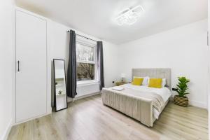 a white bedroom with a bed and a window at Modern London Apartment with WIFI in Norwood
