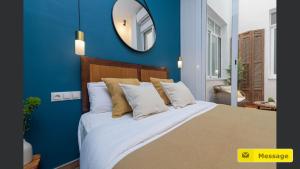 a bedroom with a large bed with a blue wall at Glamorous Niño de Guevara on The City Center in Málaga