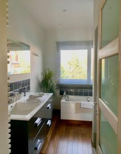 a bathroom with a tub and a sink and a tubermott at Maison entière proche tram 170 m2 jardin parking in Marcq-en-Baroeul