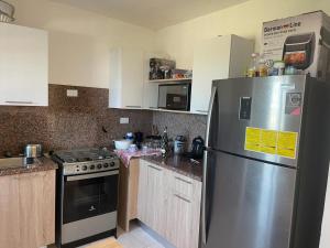 a kitchen with a stainless steel refrigerator and a stove at Caleta in La Romana
