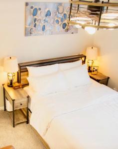 a bedroom with a white bed and two tables with lamps at HomeTel Premium Guest Suite w/ Private Entrance in Ypsilanti
