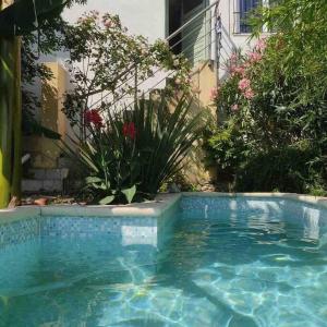 einen Pool in einem Garten mit Blumen in der Unterkunft Charmant appart 35m² dans villa in Saint-Laurent-du-Var