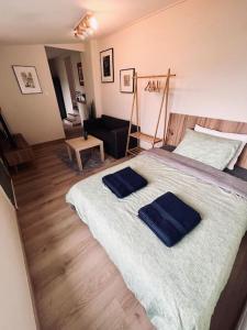 sypialnia z dużym łóżkiem z 2 niebieskimi ręcznikami w obiekcie Charmant appart 35m² dans villa w mieście Saint-Laurent-du-Var
