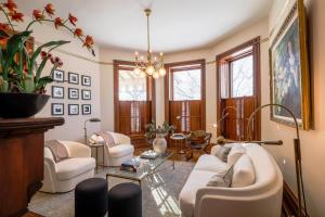 a living room with white furniture and a chandelier at Squiers 1882 in Maquoketa