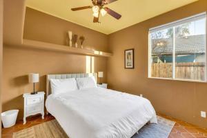 a bedroom with a bed with a ceiling fan and a window at Mediterranean Style Modern House in Sacramento