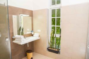 ein Bad mit einem Waschbecken und einem Spiegel in der Unterkunft Roberosia - Holiday Home in Kandy