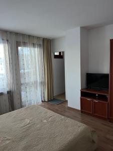 a bedroom with a bed and a flat screen tv at Hotel Daffi in Smolyan