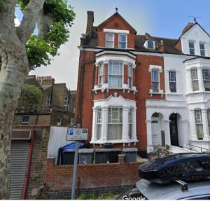 a large brick house with a sign in front of it at Callcote road Hotel in London